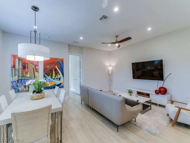 living room with ceiling fan and light hardwood / wood-style flooring