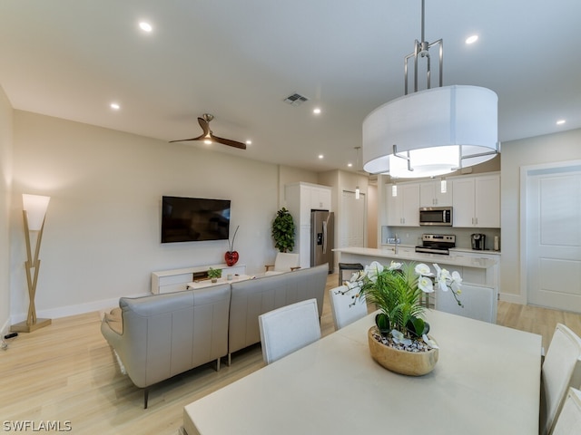 dining room featuring light hardwood / wood-style floors, ceiling fan, and sink