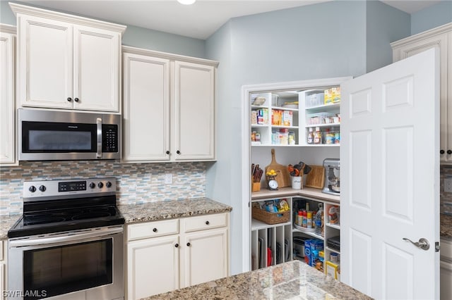 interior space with light stone countertops, tasteful backsplash, stainless steel appliances, and white cabinetry