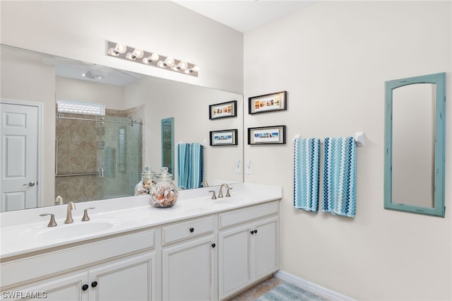 bathroom featuring double sink vanity and a shower with shower door