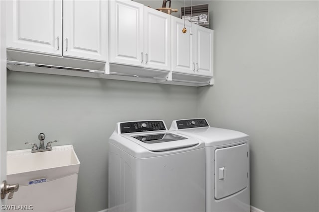 washroom featuring washer and dryer, cabinets, and sink