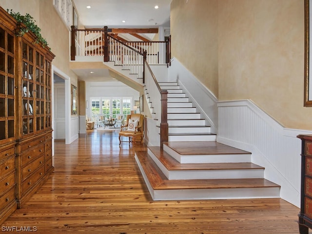 staircase featuring hardwood / wood-style floors and a towering ceiling