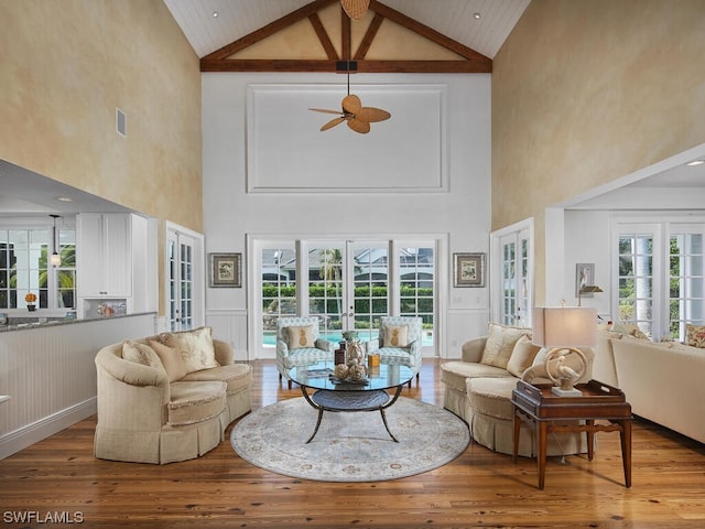 living room with wood-type flooring, lofted ceiling, and french doors