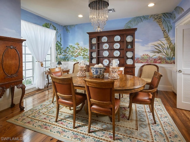 dining room with hardwood / wood-style floors and a chandelier