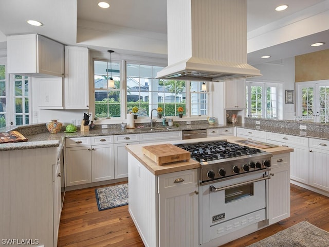 kitchen with sink, appliances with stainless steel finishes, island range hood, white cabinets, and kitchen peninsula