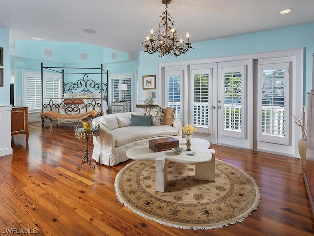 living room featuring an inviting chandelier, hardwood / wood-style flooring, and french doors