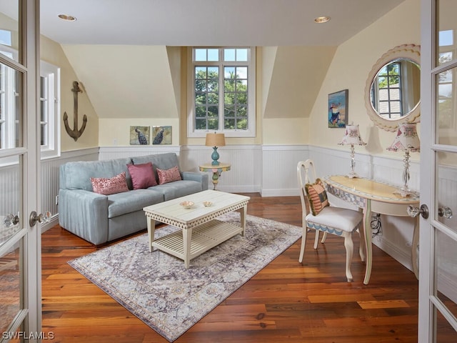 living room with vaulted ceiling, plenty of natural light, and hardwood / wood-style floors