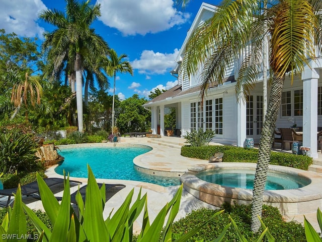 view of pool with an in ground hot tub, a patio, and french doors