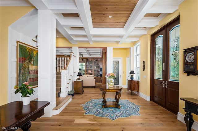 foyer entrance with coffered ceiling and light hardwood / wood-style flooring