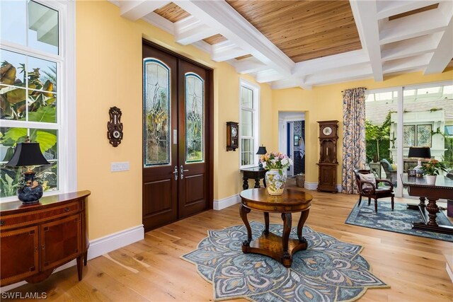 entrance foyer with light hardwood / wood-style flooring, french doors, coffered ceiling, and beamed ceiling