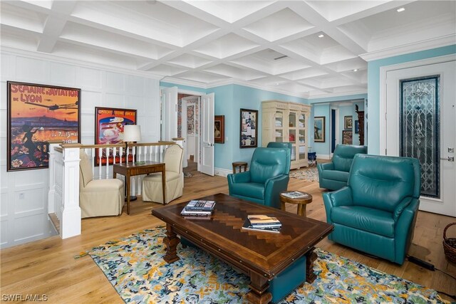 living room with beam ceiling, coffered ceiling, crown molding, and light hardwood / wood-style floors