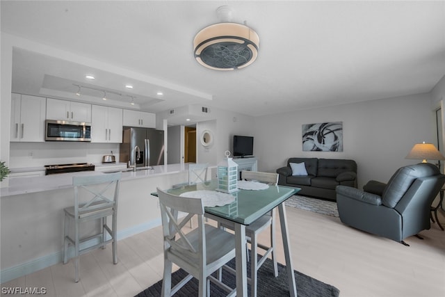 dining room featuring sink and rail lighting