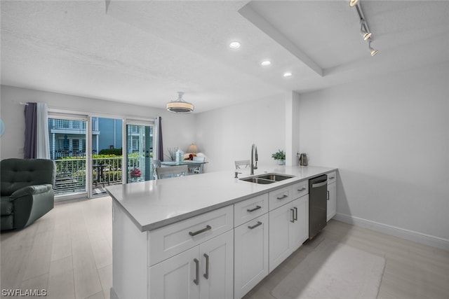 kitchen with sink, kitchen peninsula, white cabinets, and a textured ceiling