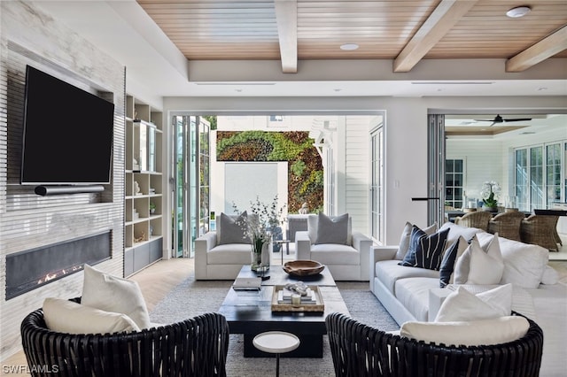 living room with ceiling fan, wood ceiling, and beam ceiling