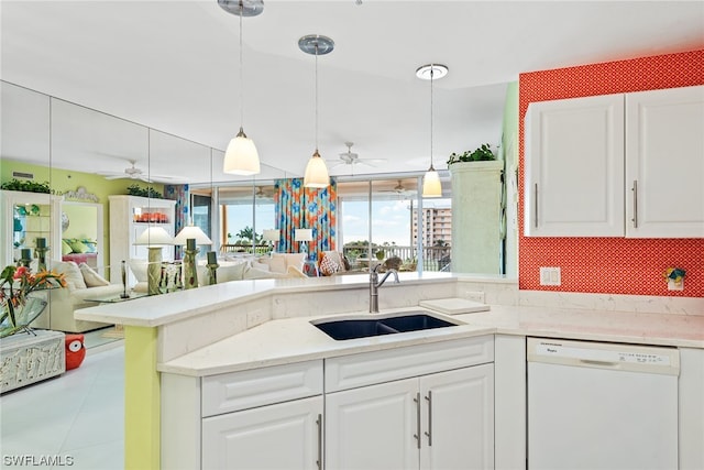 kitchen featuring white dishwasher, white cabinets, sink, hanging light fixtures, and ceiling fan