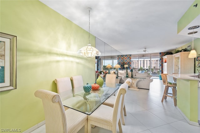 tiled dining area with ceiling fan with notable chandelier