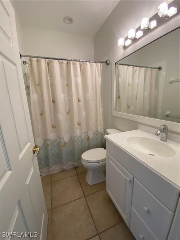 bathroom with tile patterned flooring, vanity, and toilet