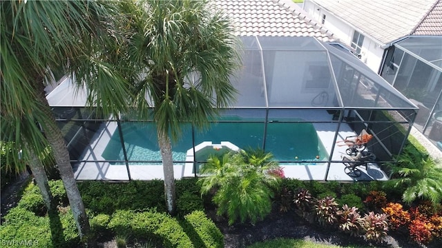 view of swimming pool featuring glass enclosure