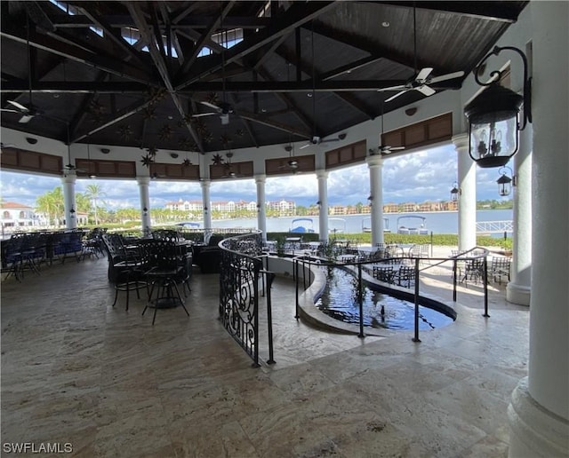 view of dock featuring a gazebo, a water view, and a patio