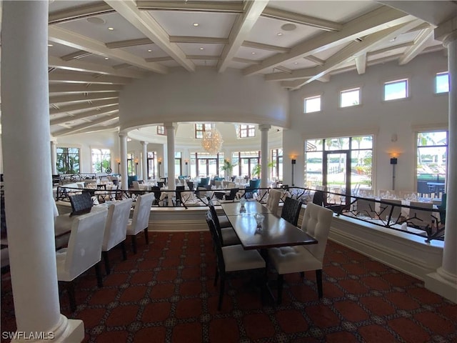 dining room with a towering ceiling, a healthy amount of sunlight, beam ceiling, and decorative columns