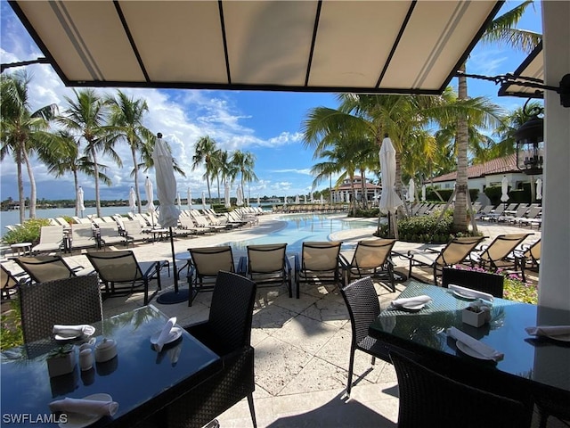 view of patio / terrace featuring a community pool and a water view