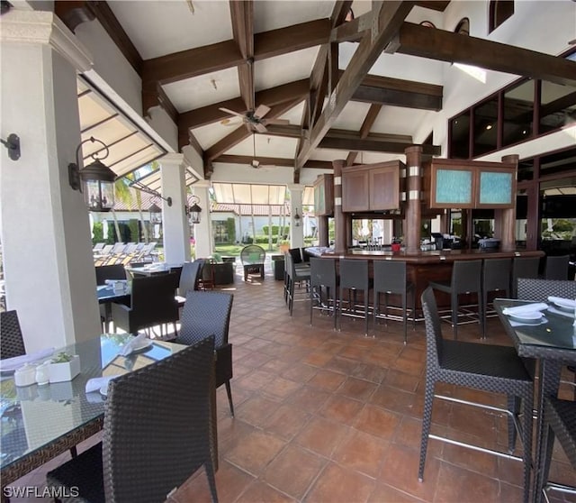 view of patio with ceiling fan and a bar