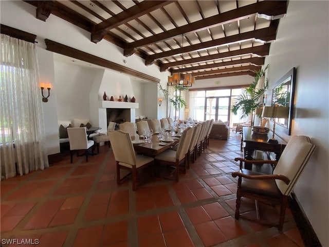 dining space with beamed ceiling and dark tile patterned flooring