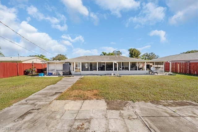 back of house featuring a lawn and a sunroom