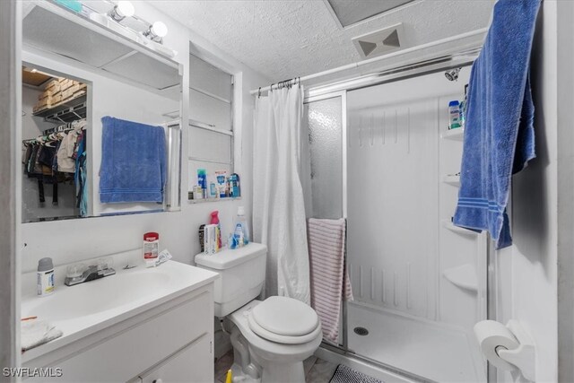 bathroom featuring a shower, a textured ceiling, vanity, and toilet