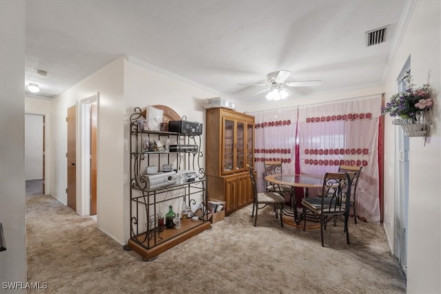 dining space featuring carpet flooring, ceiling fan, and crown molding