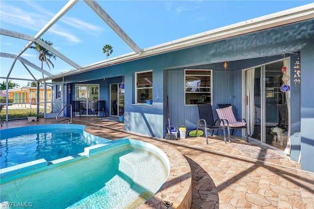 view of pool with a patio area, a lanai, and a pool with connected hot tub