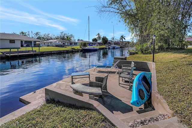 dock area with a water view, a residential view, and a lawn