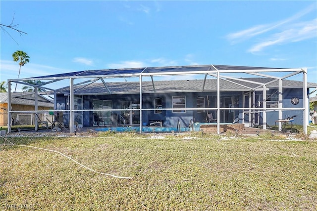 rear view of property with a lanai and a yard