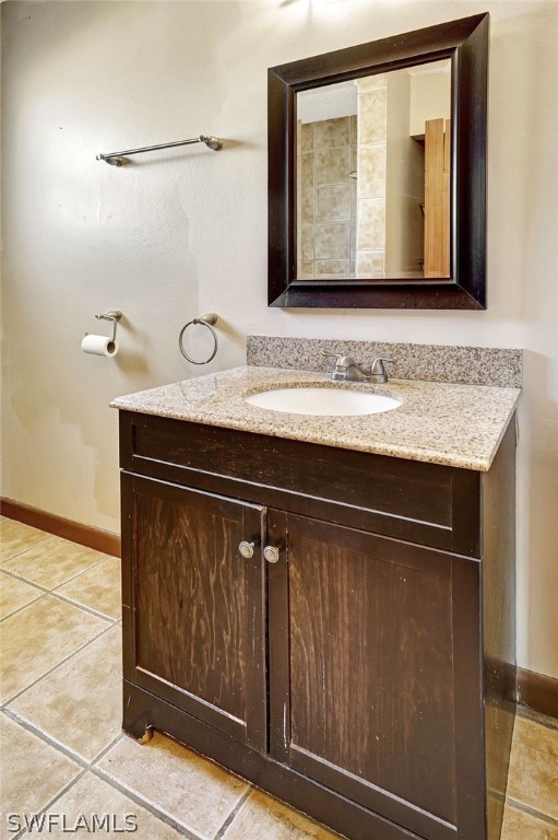 bathroom with tile patterned flooring, vanity, and baseboards