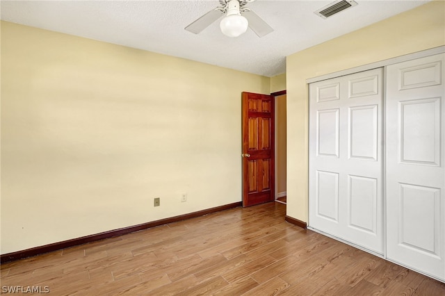 unfurnished bedroom featuring a closet, visible vents, ceiling fan, light wood-type flooring, and baseboards