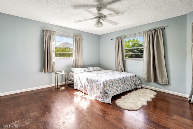 bedroom featuring wood-type flooring, multiple windows, and baseboards