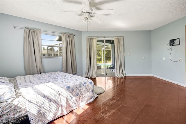 bedroom with access to outside, multiple windows, wood finished floors, and baseboards