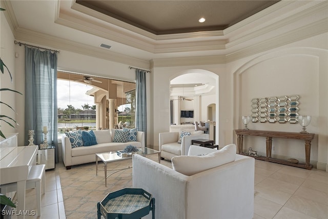 tiled living room with crown molding, a raised ceiling, and ceiling fan