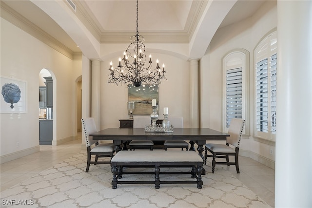 tiled dining space featuring ornamental molding, a chandelier, a wealth of natural light, and decorative columns