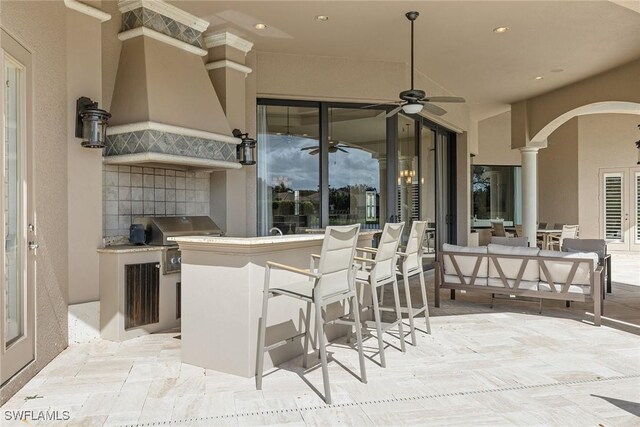 view of patio featuring an outdoor kitchen, an outdoor hangout area, an outdoor bar, ceiling fan, and area for grilling