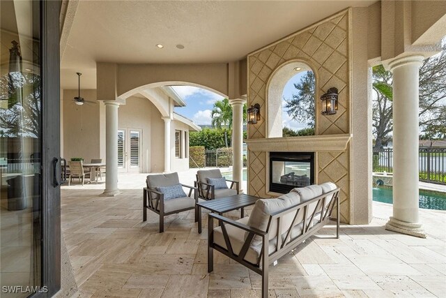 view of patio / terrace with an outdoor living space with a fireplace and a water view