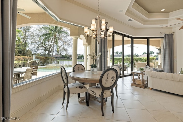 tiled dining area featuring crown molding, a healthy amount of sunlight, ceiling fan with notable chandelier, and a water view