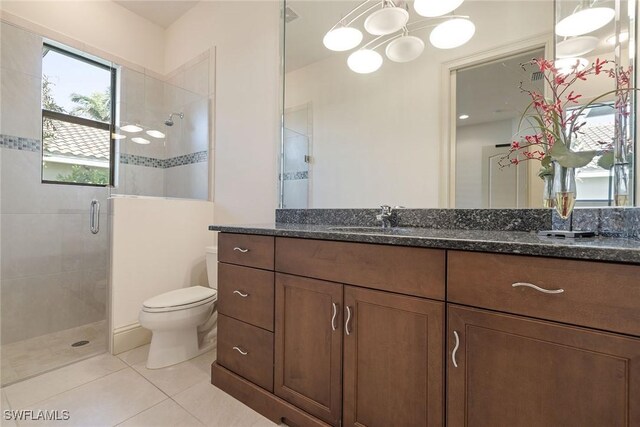 bathroom featuring vanity, tile patterned floors, toilet, and an enclosed shower