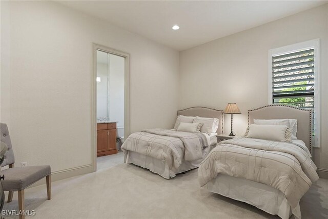 carpeted bedroom featuring ensuite bath