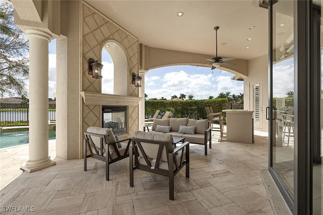 view of patio with a fenced in pool, an outdoor living space with a fireplace, and ceiling fan