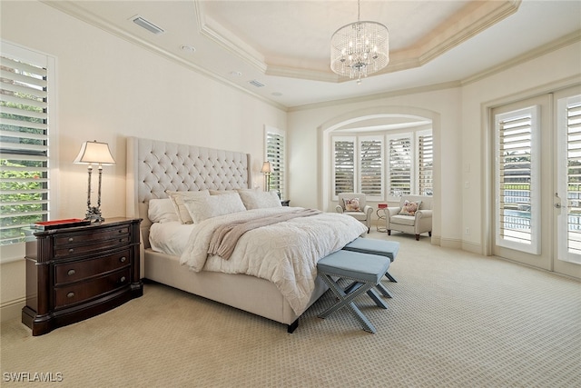 carpeted bedroom with crown molding, a raised ceiling, access to outside, and an inviting chandelier