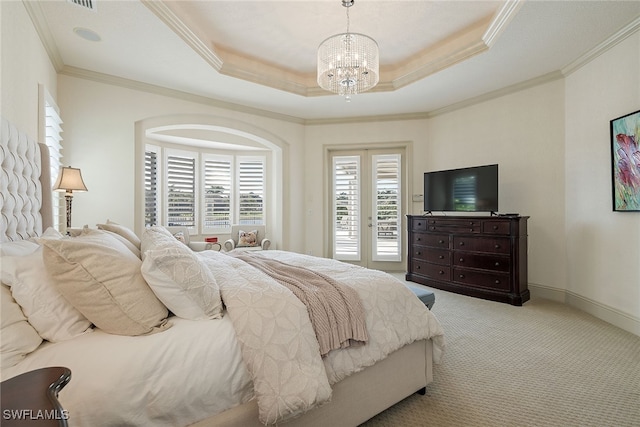 carpeted bedroom with a tray ceiling, a notable chandelier, access to outside, and ornamental molding