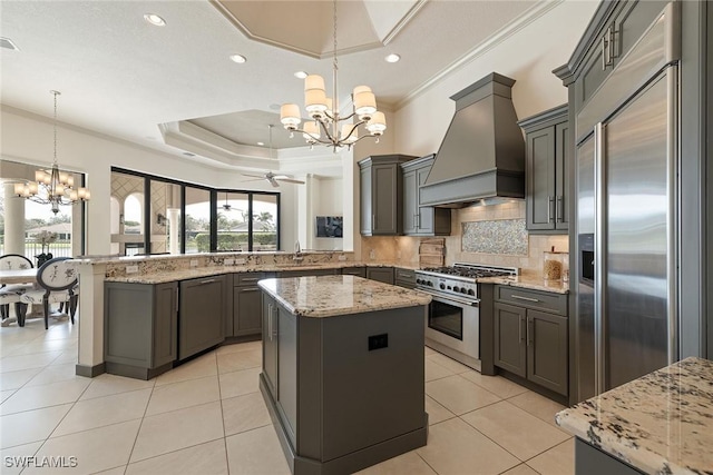 16540 Cellini Ln, Naples, FL 34110 - kitchen featuring crown molding, premium range hood, a peninsula, high end appliances, and a healthy amount of sunlight