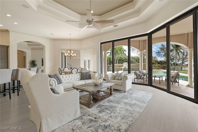 16540 Cellini Ln, Naples, FL 34110 - living room featuring crown molding, arched walkways, and light wood finished floors