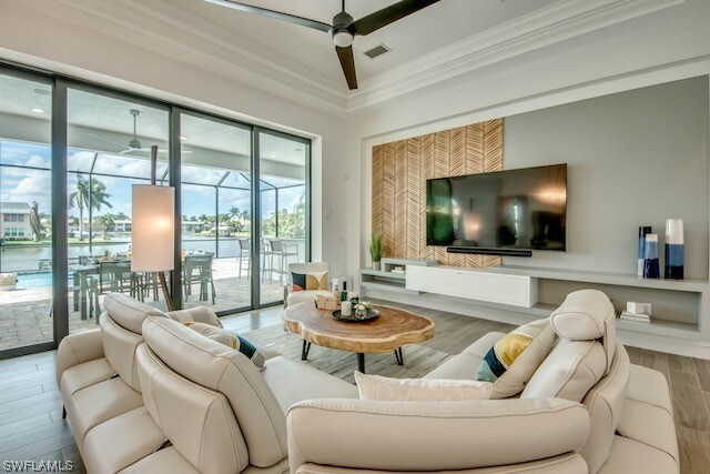 living room with ornamental molding, ceiling fan, hardwood / wood-style flooring, and a healthy amount of sunlight